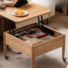 a person sitting at a table with an open drawer in front of them, reading a book