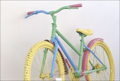 a colorful bike is shown against a white wall with the handlebars down and it's painted in pastel colors