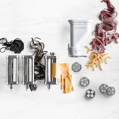 several different types of pasta cutters on a white counter top next to other kitchen gadgets