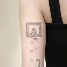 a woman with a tattoo on her arm holding a framed flower and an umbrella in the background