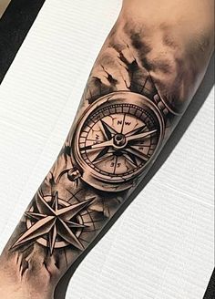 a man's arm with a compass tattoo on it and an ink pen in the middle