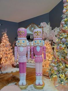 two nutcrackers standing next to each other in front of a christmas tree