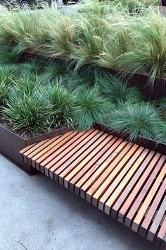 a bench made out of wooden slats and grass growing on top of the slats