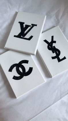 three black and white paintings with letters on them