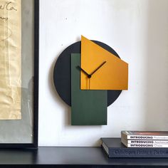 a clock that is on the side of a wall next to books and a book