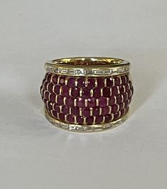 Boucheron Bandeau ring in yellow gold (18k), the domed center decorated with a pavé of round natural rubies between two lines of natural baguette-cut diamonds. Signed and numbered. Width: 21mm. Gross Weight: 17.10 g. Size: 51 Possibility of sizing, contact us. Further information : We issue an invoice as well as a certificate of authenticity established by our qualified gemologist (LFG Paris). Our photos are not reworked and are taken in a natural light environment. We can send you a short video Luxury Baguette-cut Ruby Ring In Yellow Gold, Anniversary Yellow Gold Ruby Ring With Baguette Diamonds, Luxury Ruby Ring With Baguette Diamonds, Luxury Ruby Ring With Baguette Diamonds For Anniversary, Ruby Band Ring, Ruby Bands, Baguette Cut Diamond, Baguette Cut, Multi Stone Ring