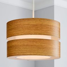 a wooden light fixture hanging from the ceiling in a room with white walls and flooring