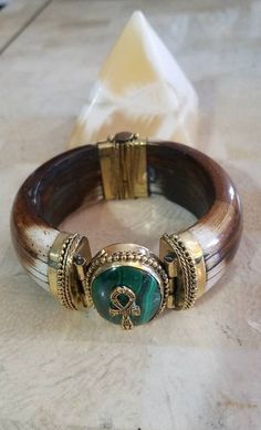 Subscribe to our newsletter NOW: http://eepurl.com/dEBXqb. BUY today and save 10% off all purchases of $50 or more (NEXTORDER10), plus free shipping within the USA!  This is it. Gorgeous Egyptian-inspired jewelry. This unique horn bone bracelet has a beautiful bronze-plated lead-free pewter ankh pendant on a Malachite crystal stone. This item will add a touch of ancient Egypt to your outfit.  The ancient Egyptian symbol - Ankh. The Ankh is the key to life, the legend of the Nile. It represents the concept of eternal life, which is the general meaning of the symbol.  With the wisdom of the Malachite crystal, progress isn't measured in material riches but with spiritual treasures found deep within the heart. But this enchanting stone also has a practical side. The Malachite meaning brings us Ancient Egypt Jewelry, Egyptian Inspired Jewelry, Egyptian Clothing, Bone Bracelet, Funky Accessories, Egypt Jewelry, Ankh Pendant, Ancient Egyptian Symbols, Dope Jewelry Accessories