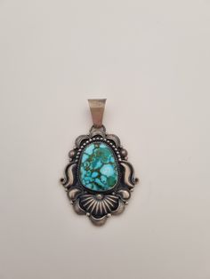 a pendant with a turquoise stone in the center