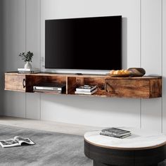 a flat screen tv sitting on top of a wooden shelf