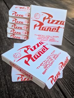 four pizza place cards sitting on top of a wooden table