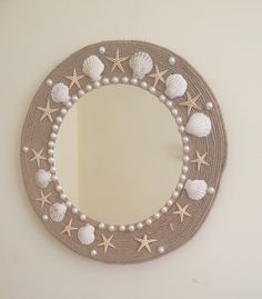 a mirror with shells and pearls hanging on the wall