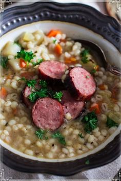 a bowl filled with soup and sausage on top of it