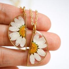 Set of half circle daisy necklaces being held in a hand. Adjustable Everyday Flower-shaped Jewelry, White Flower Charm Jewelry For Friendship, White Jewelry With Flower Charm For Friendship, White Sterling Silver Jewelry For Friendship Gifts, White Daisy Jewelry For Everyday, White Sterling Silver Jewelry For Friendship, White Daisy-shaped Everyday Jewelry, Everyday White Birth Flower Jewelry, Everyday White Daisy Shaped Jewelry