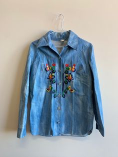 "Vintage Embroidered Two Piece Denim Pant & Jacket Set with butterfly and floral stitched detail.  Button Up Measurements Size No tag fits like Med/Large Length  27\" Shoulder to shoulder  17.5\" Pit to pit  19\" Sleeve  22\" Pants (measured laying flat) Measurements Size Tag hard to read, maybe size 16 Waist  14.5\" Inseam to Waist  14\" Inseam to ankle 29.5\" Ankle width. 11\"" Vintage Long Sleeve Denim Jacket For Spring, Fitted Jeans With Snap Buttons For Spring, Fitted Tops With Butterfly Embroidery For Spring, Fitted Top With Butterfly Embroidery For Spring, Fitted Butterfly Embroidery Top For Spring, Fitted Jeans With Buttons For Spring, Vintage Floral Embroidered Jeans For Spring, Spring Embroidered Cotton Jeans, Embroidered Long Sleeve Denim Jacket For Summer