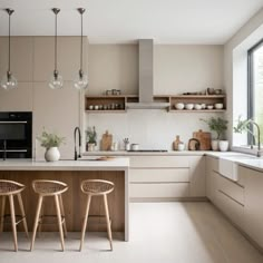 two stools sit in front of a kitchen island with white countertops and beige cabinets