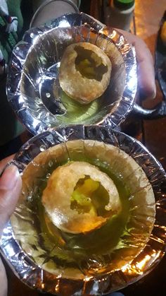 two pies sitting on top of tin foil covered pans filled with green liquid