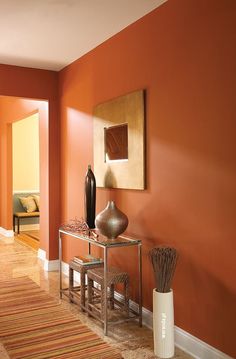 an orange room with two vases on the table