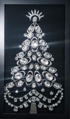 a christmas tree made out of diamonds in a black shadow box with a white background