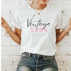 Unique vintage birthday shirts - personalized for your party Celebrate your special day with a unique, personalized vintage birthday shirt! Our lovingly designed shirt combines nostalgic charm with modern comfort. Each shirt is customized for you, with your name and year of birth to add a personal and meaningful touch. Enjoy high-quality materials and a timeless design that is perfect for any birthday celebration. A great gift for friends, family or for yourself - make your birthday unforgettabl Vintage Birthday T-shirt With Text Print, Vintage Short Sleeve Tops For Gift, Vintage White T-shirt For Birthday, Vintage Graphic Print Tops As Gift, Vintage Graphic Print Tops For Gifts, Vintage Crew Neck Top As Gift, Vintage Letter Print Tops For Anniversary, Retro Letter Print Tops As Gift, Retro Letter Print Tops For Gifts