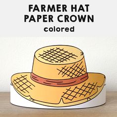 a paper hat with the words farmer hat in black and white above it, on top of a wooden table