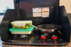 a stove top with some containers on it and a pan sitting on the burner