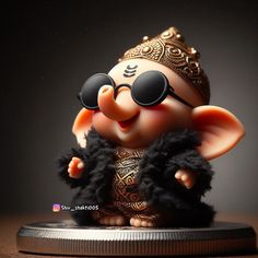 an elephant figurine with sunglasses on top of a round object in front of a dark background