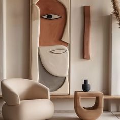 an abstract painting hangs on the wall next to a modern chair and table with vases