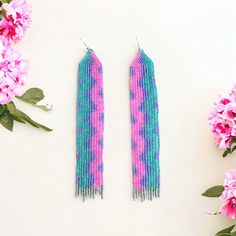 Turquoise Purple And Pink Long Seed Bead Fringe Beaded Earrings Wavy Shimmer Dimensions 5.75”L X 1”W Elevate Your Style With Our Turquoise And Pink Long Seed Bead Fringe Earrings. Adorned With A Colorful Wavy Pattern, These Handwoven Earrings Add A Touch Of Playful Sophistication To Any Outfit. The Shiny Beads In Turquoise, Purple, Pink, And Silver Come Together To Create A Unique And Exclusive Piece That Will Make A Statement Wherever You Go. These Elegant Seed Bead Earrings Are Handwoven With Turquoise Beaded Earrings With Beaded Chain, Turquoise Beaded Chain Earrings, Purple Beaded Earrings With Round Beads For Festival, Festival Purple Beaded Earrings With Round Beads, Bohemian Purple Beaded Earrings For Beach, Summer Purple Beaded Jewelry, Purple Beaded Dangle Earrings For Beach, Purple Colorful Beaded Earrings For Festival, Adjustable Turquoise Beaded Earrings For Party