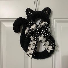 a door hanger decorated with black and white bows