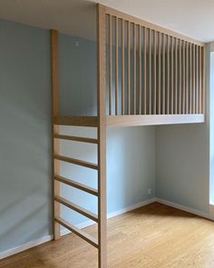 an empty room with a wooden staircase next to a window