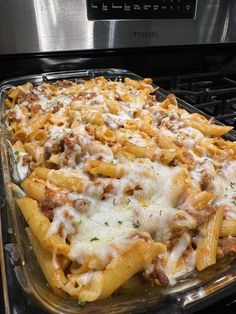 a casserole dish with meat, cheese and sauce on it in an oven