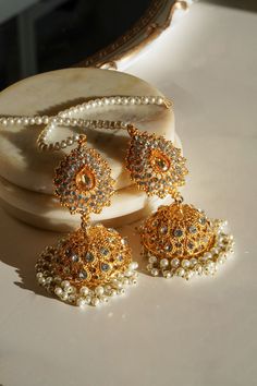 Introducing the "Tania" Lightweight Jhumka adorned with a Beaded Tana Chain, where traditional charm meets modern elegance. These captivating jhumkas are a testament to artisanal finesse, designed to add a touch of sophistication to every step you take. Features: Elegantly Lightweight: Embrace a new level of comfort with our jhumkas, thoughtfully crafted to ensure you remain at ease while exuding timeless style. From dawn's first light to dusk's embrace, these jhumkas become an effortless extens Pakistani Earrings, Wedding Jewelry Sets Bridal Jewellery, Jhumka Designs, Indian Wedding Jewelry Sets, Classy Earrings, Fancy Jewellery Designs, Pakistani Jewelry, Gold Jewelry Simple, Indian Wedding Jewelry