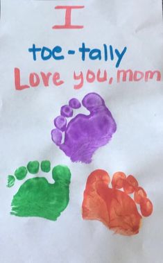 a paper sign that says i toe - tally love you mom and two hand prints