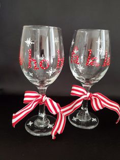 two wine glasses decorated with red and white ribbon, one has the word love on it