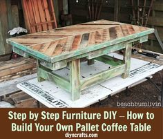 a table made out of pallet wood sitting on top of a wooden bench in front of a building