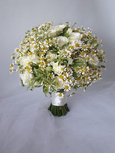 a bouquet of white and yellow flowers in a vase