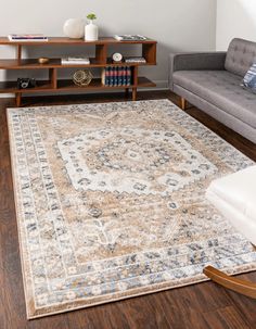 a living room area with a couch, coffee table and rug on the hardwood floor