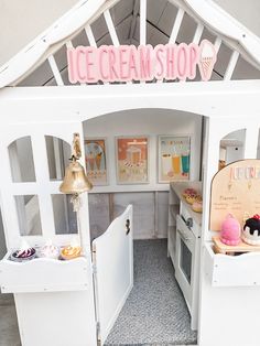 an ice cream shop with lots of white furniture and decorations on the front door area