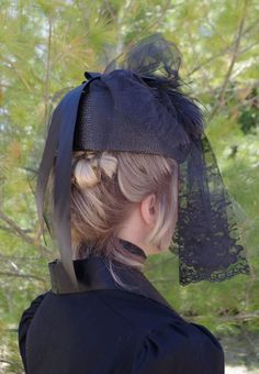 Enter as a lady of mystery with this most-refined piece of mourning clothing. You will know for sure that you are following the highest society standards for the occasion when you place this hat on your head. Discreetly shield your face with the delicate lace veil or attach it to the top of the hat when the appropriate moment presents itself. Made of the highest quality materials, the hat includes a thick black ribbon in the back and feathers and a bow in front. Perfect for macabre-themed events Elegant Black Hat For Costume, Elegant Black Costume Hat, Elegant Black Costume Top Hat, Elegant Black Top Hat For Costume, Black Curved Brim Costume Hat For Church, Black Costume Hat With Curved Brim For Church, Black Costume Hat For Church With Curved Brim, Black Costume Hats For Church, Elegant Black Costume Headpiece