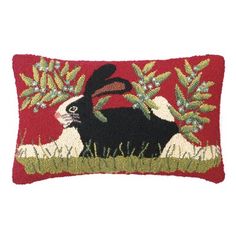 a red pillow with a black and white rabbit on it