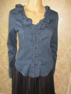 Black long sleeved shirt with a ruffled neck line and  button band.  The back is stretchy and the front cotton.  It has buttons to close and buttons on the cuffs. Bust pit to pit flat;  19" Length;  22" Inside arm;  19" Made by PORTO FORTUNA Chic Fitted Shirt With Ruffled Collar, Fitted Cotton Tops With Ruffles, Stretch Fall Blouse With Buttons, Stretch Blouse With Buttons For Fall, Fitted Tops With Ruffles And Ruffled Collar, Fitted Cotton Blouse With Ruffles, Elegant Stretch Tops With Ruffled Collar, Elegant Stretch Top With Ruffled Collar, Elegant Stretch Shirt For Fall