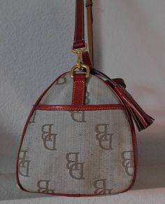 "Canvas crossbody/satchel Canvas has four tone color: beige, gold, brown and light blue Logo in brown Red leather trim, strap and tassel and handle Zipper closure with tassel Gold hardware Adjustable strap Front layout: two side open pockets, a compartment with red leather flap and snap Interior layout: a key chain, one zipper compartment and open pocket, two compartments on the opposite wall with snap Normal wear signs, a small cut at the bottom on back side, about 1/4\" long. See photos for qu Vintage Coated Canvas Satchel With Gold-tone Hardware, Canvas Satchel, Interior Layout, Western Belt Buckles, Crossbody Satchel, Western Belts, Blue Logo, Cross Body Bag, Canvas Leather