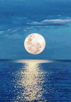 the full moon shines brightly in the sky above the ocean and reflects on the water