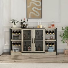 a cabinet with wine glasses and bottles in it next to a potted plant on the floor