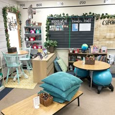 a room with tables, chairs and bookshelves on the walls is decorated with greenery