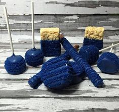 several blue candy lollipops are sitting on a wooden table next to each other