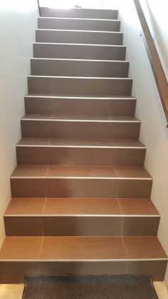 a set of wooden stairs leading up to the top floor in a house or office