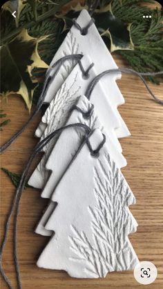 three white ceramic christmas trees on a wooden table