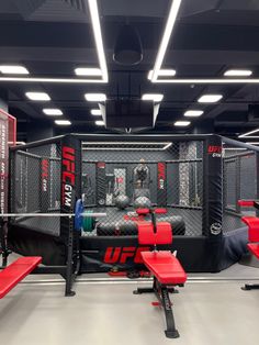 the inside of a boxing gym with red benches